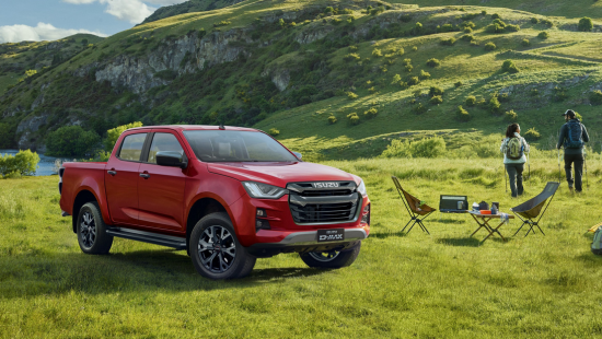Isuzu D-Max parked on green field with camping table and drinks