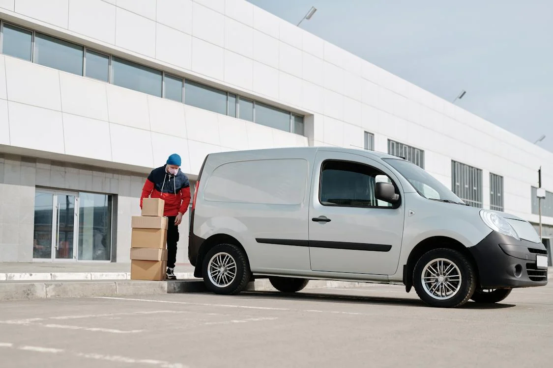 man loading a white van with boxes