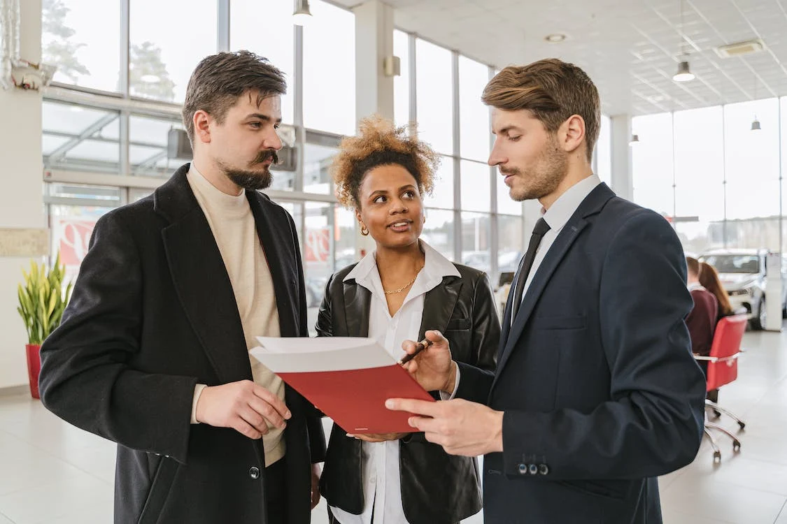 two men and woman looking over a contract